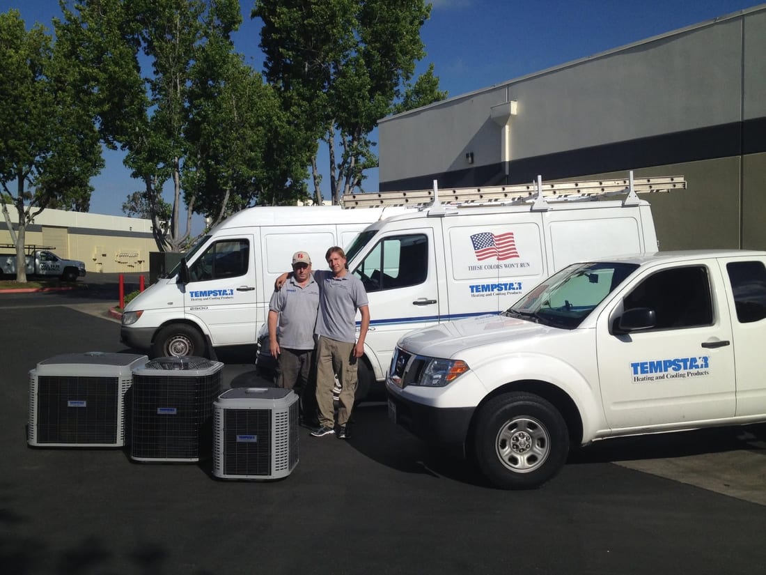George and Victor Krivoshey standing by company vans